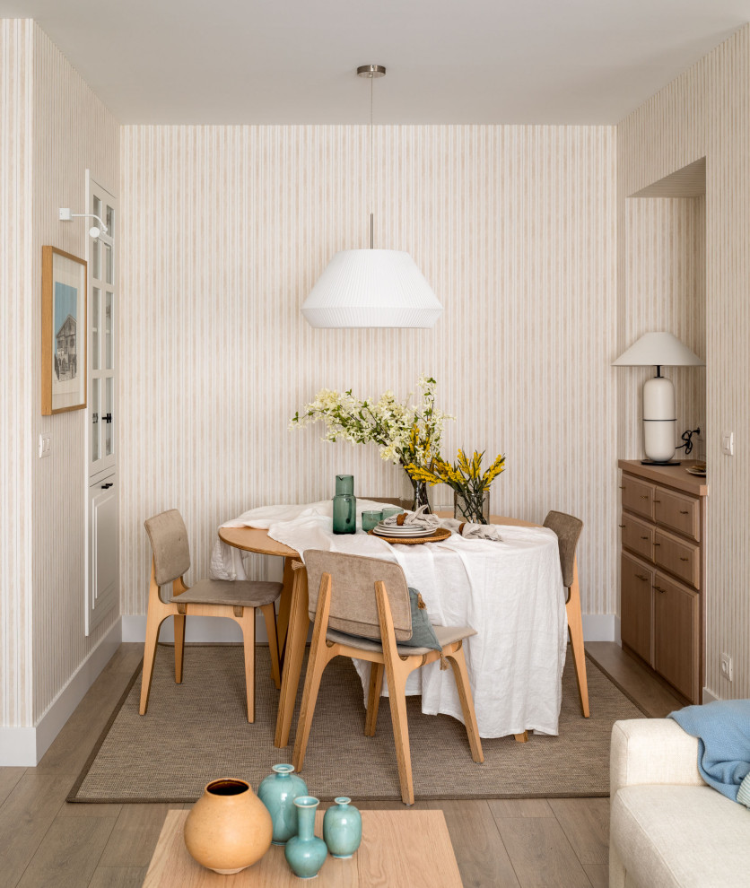 Ejemplo de comedor marinero pequeño abierto sin chimenea con paredes beige, suelo laminado, suelo beige, papel pintado y alfombra
