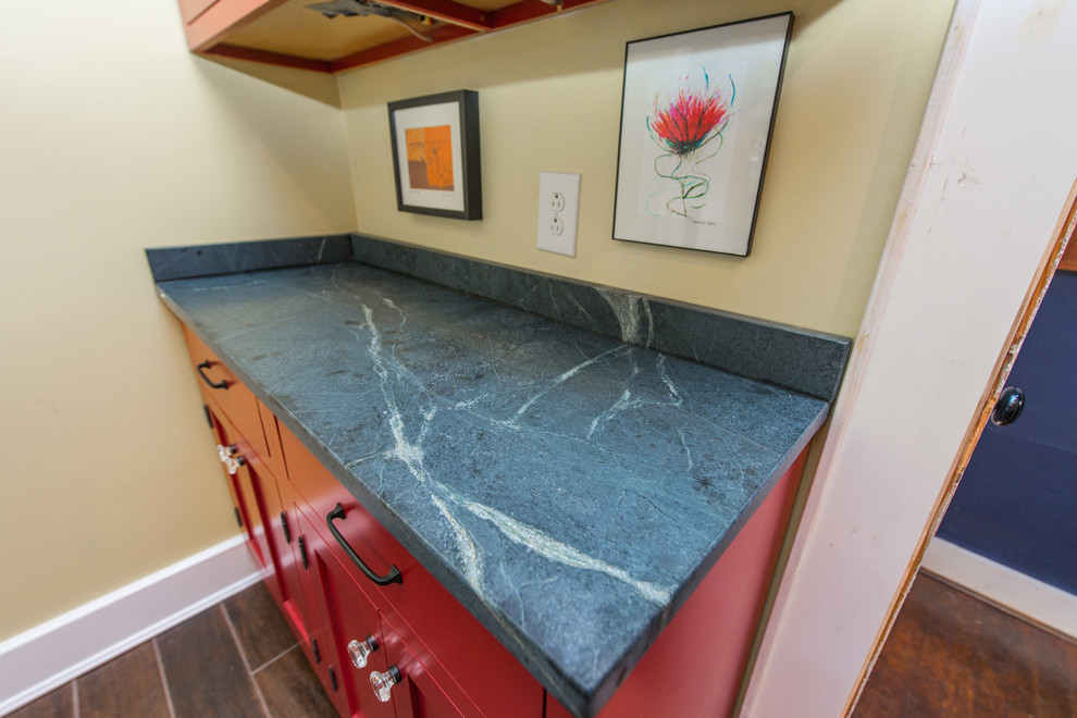 Eat-in kitchen - mid-sized contemporary galley dark wood floor and brown floor eat-in kitchen idea with a double-bowl sink, raised-panel cabinets, red cabinets, soapstone countertops, stainless steel appliances and an island