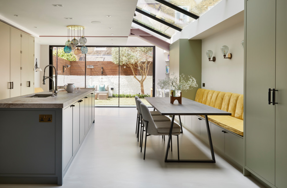 Exemple d'une grande cuisine ouverte linéaire moderne avec un placard à porte affleurante, des portes de placards vertess, un plan de travail en quartz, îlot et un sol gris.