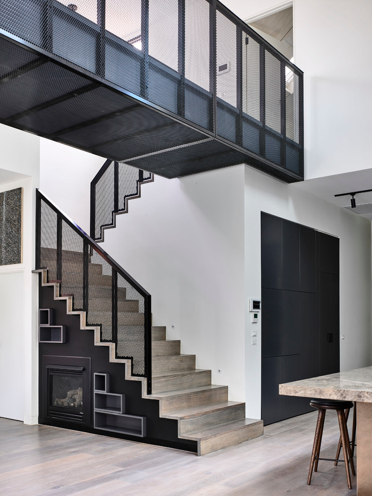 This is an example of a large contemporary wood u-shaped staircase in Melbourne with wood risers.