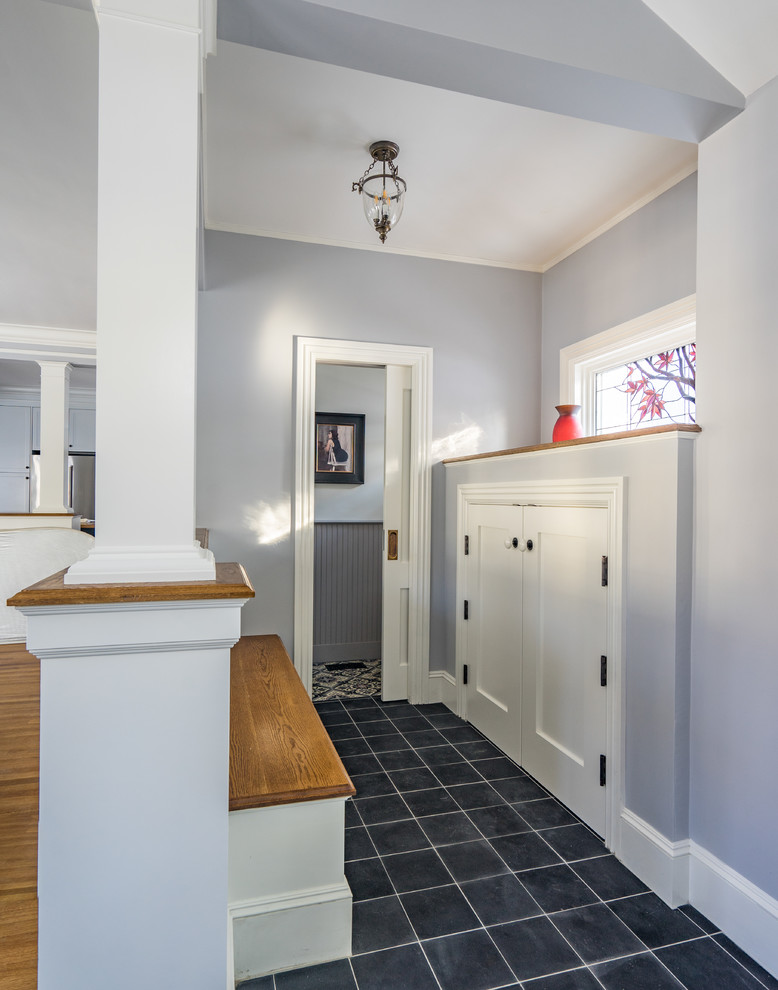 Photo of a large traditional hallway in Boston with grey walls, concrete floors and black floor.