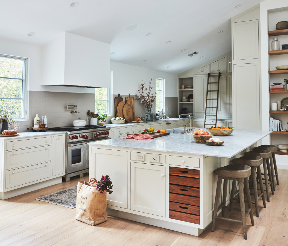 Kitchen - mid-sized transitional kitchen idea in Los Angeles with beige backsplash, ceramic backsplash, stainless steel appliances and an island