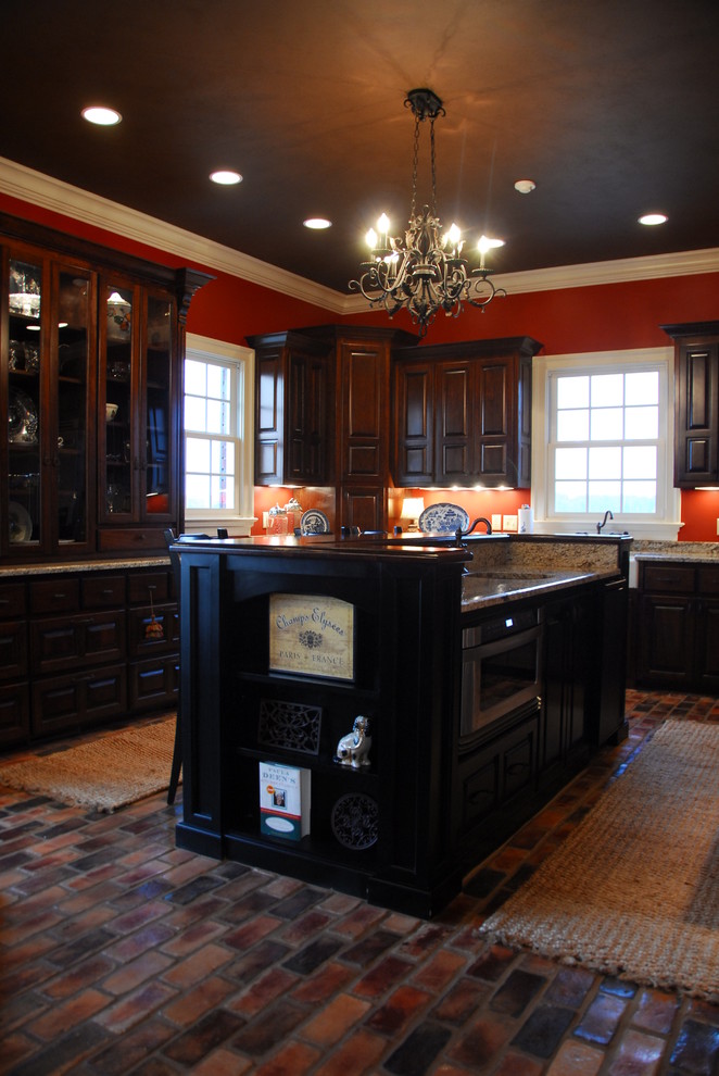 Inspiration for a large traditional u-shaped eat-in kitchen in Atlanta with a farmhouse sink, raised-panel cabinets, dark wood cabinets, granite benchtops, stainless steel appliances, brick floors, with island and multi-coloured floor.