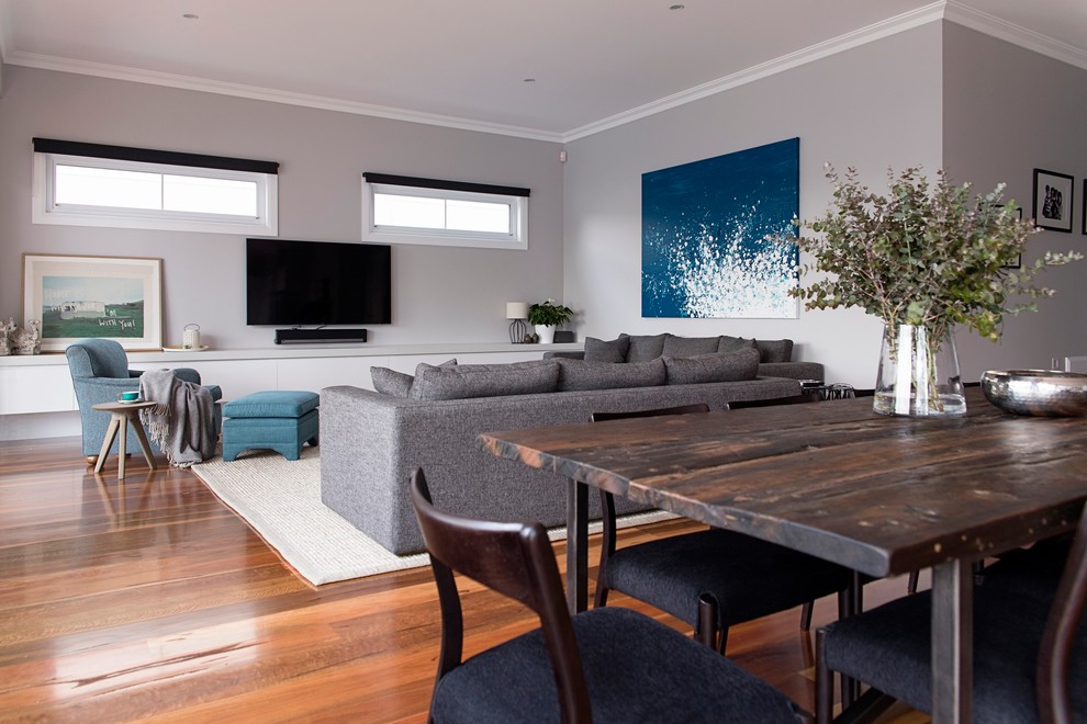 This is an example of a large contemporary open concept family room in Melbourne with grey walls and light hardwood floors.