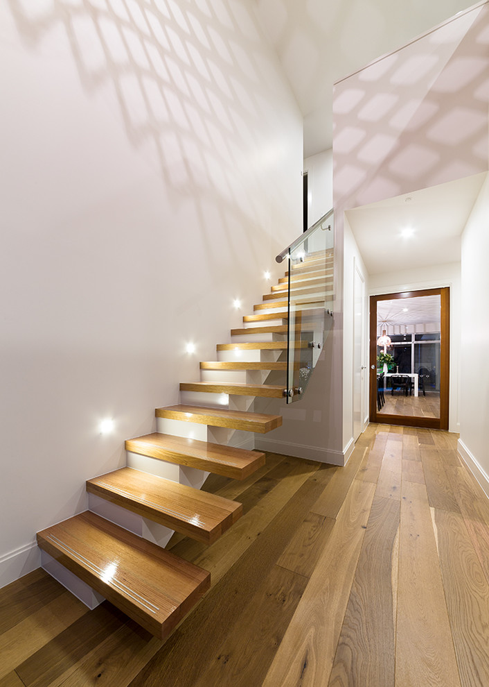 Photo of a mid-sized contemporary wood floating staircase in Adelaide with open risers.