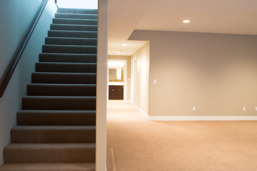 Mid-sized transitional underground carpeted basement photo with beige walls