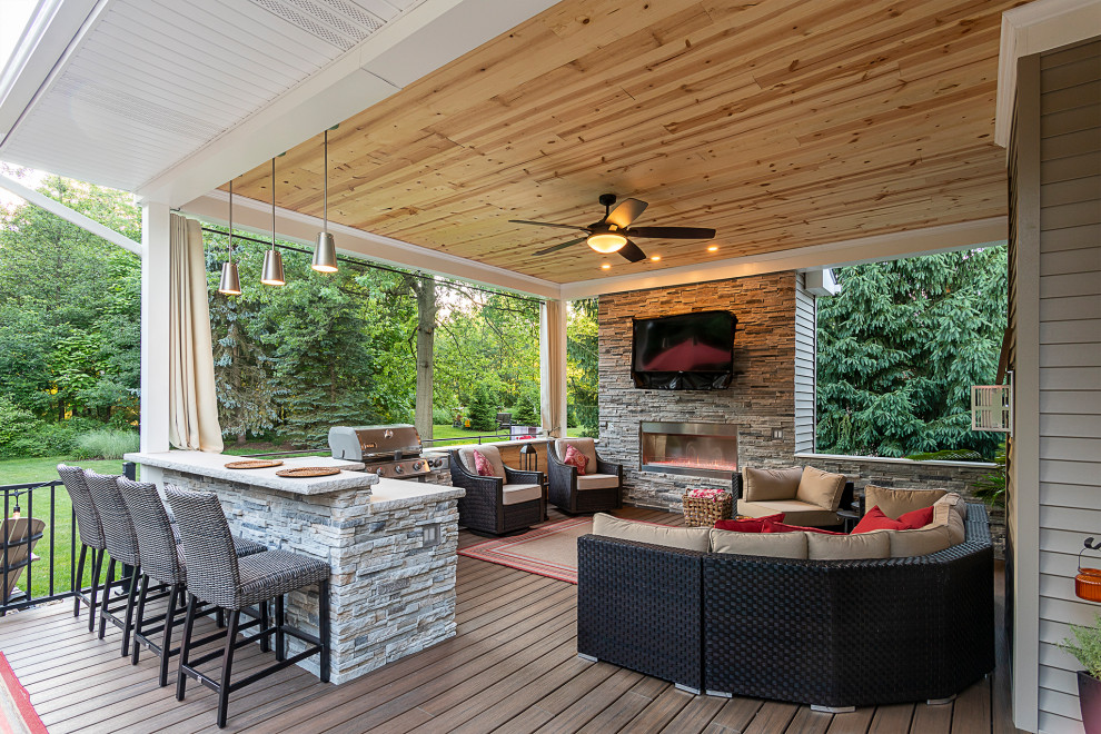 Inspiration for a transitional ground level deck in Cleveland with with fireplace, a roof extension and metal railing.