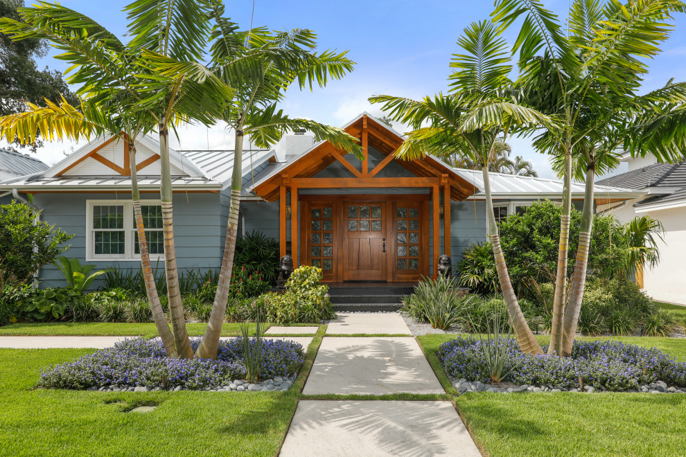 Inspiration for a tropical one-storey grey house exterior in Tampa with a gable roof and a metal roof.