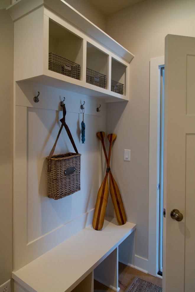 Mid-sized beach style mudroom in Kansas City with beige walls, light hardwood floors, a single front door, a white front door and brown floor.