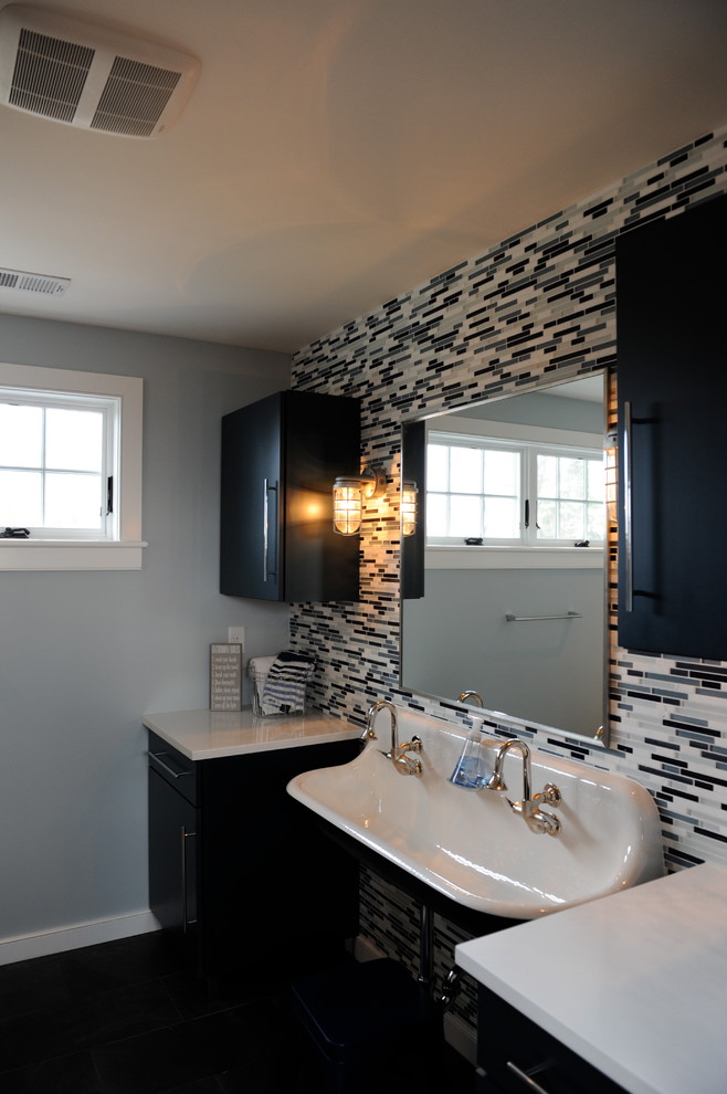 Inspiration for a mid-sized transitional master bathroom in New York with flat-panel cabinets, black cabinets, beige tile, black tile, gray tile, white tile, glass tile, grey walls, dark hardwood floors, a trough sink, solid surface benchtops and brown floor.