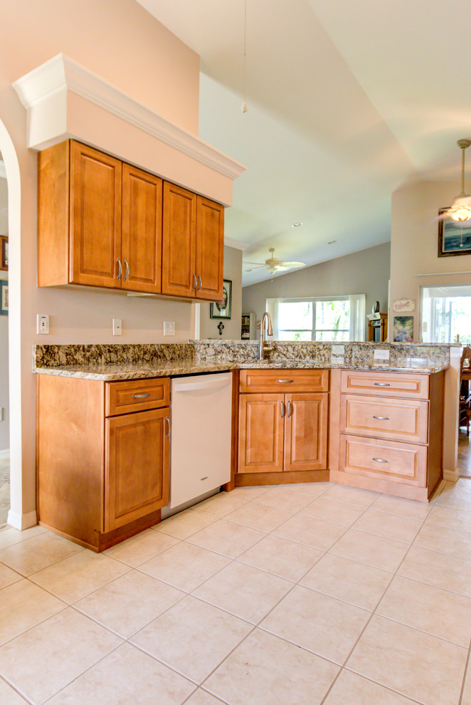 Inspiration for a mid-sized kitchen remodel with an undermount sink, raised-panel cabinets, medium tone wood cabinets, granite countertops, white appliances and brown countertops