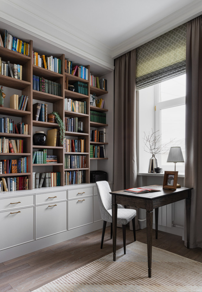 Idée de décoration pour un bureau tradition de taille moyenne avec une bibliothèque ou un coin lecture, un mur blanc, un sol en bois brun, un bureau indépendant et un sol gris.