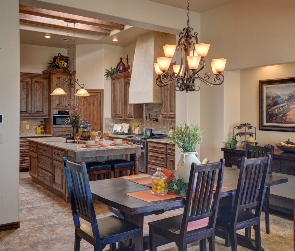 This is an example of a mediterranean eat-in kitchen in Austin with an undermount sink, raised-panel cabinets, medium wood cabinets, granite benchtops, brown splashback, stone tile splashback, stainless steel appliances, porcelain floors and with island.