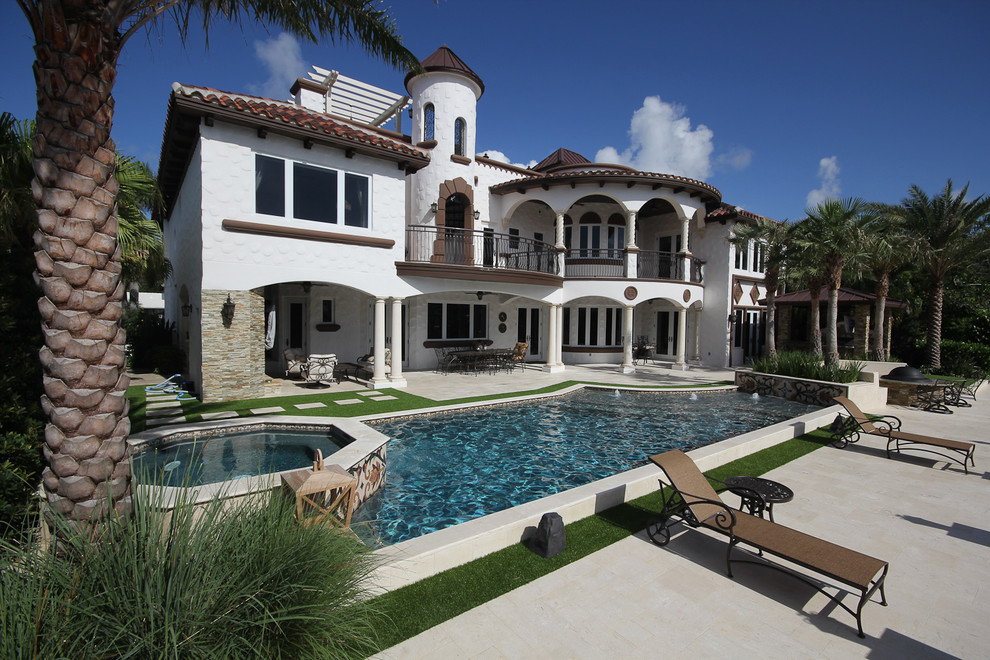 Example of a large tuscan backyard tile and custom-shaped lap hot tub design in Miami