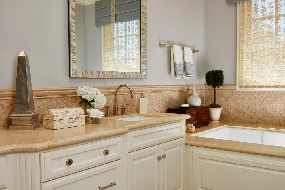 Mid-sized traditional master bathroom in San Francisco with raised-panel cabinets, white cabinets, an undermount tub, beige tile, mosaic tile, grey walls, marble floors, an undermount sink and marble benchtops.