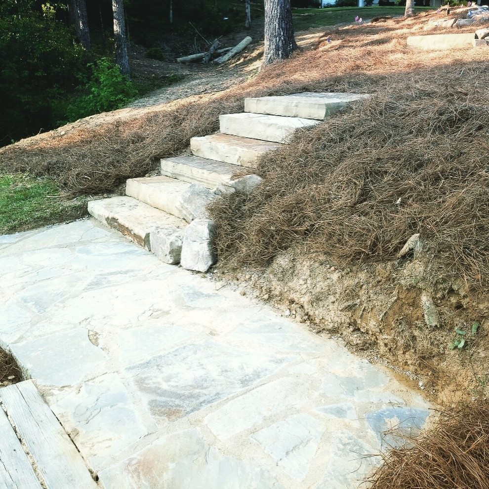 This is an example of a traditional backyard garden in Birmingham with a fire feature and natural stone pavers.