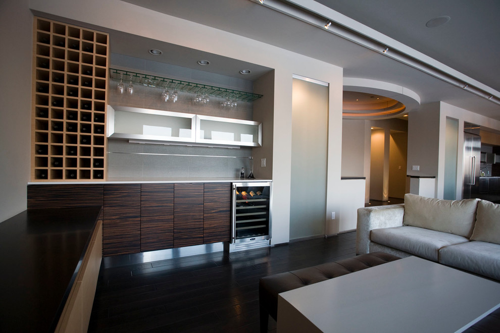 This is an example of a large modern single-wall wet bar in Minneapolis with flat-panel cabinets, brown cabinets, quartz benchtops, grey splashback and dark hardwood floors.