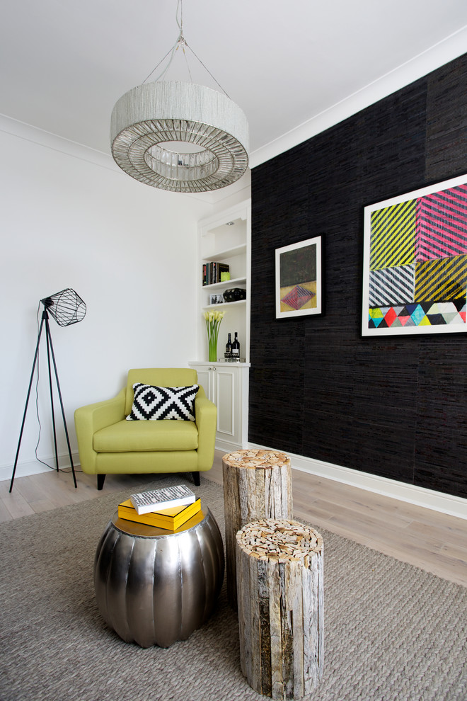 This is an example of a contemporary living room in London with black walls and light hardwood floors.