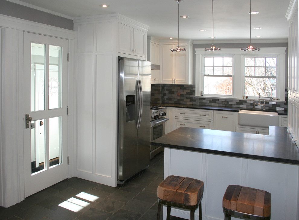 Mid-sized transitional l-shaped slate floor eat-in kitchen photo in Boston with a farmhouse sink, raised-panel cabinets, white cabinets, granite countertops, metallic backsplash, metal backsplash, stainless steel appliances and an island