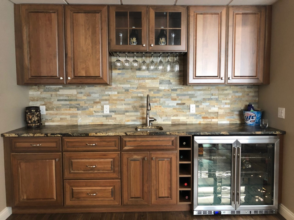 Example of a small transitional single-wall porcelain tile and brown floor kitchen design with an undermount sink, raised-panel cabinets, medium tone wood cabinets, marble countertops, beige backsplash, limestone backsplash, stainless steel appliances and brown countertops