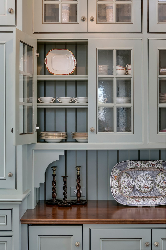 Inspiration for a cottage eat-in kitchen remodel in Raleigh with an island, wood countertops, glass-front cabinets and gray cabinets