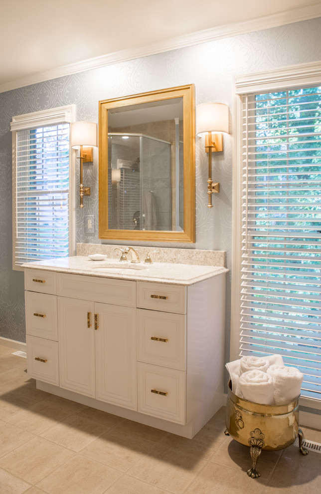 This is an example of a mid-sized contemporary master bathroom in Cedar Rapids with blue walls, recessed-panel cabinets, white cabinets, ceramic floors, an undermount sink, engineered quartz benchtops, beige floor, a single vanity and wallpaper.