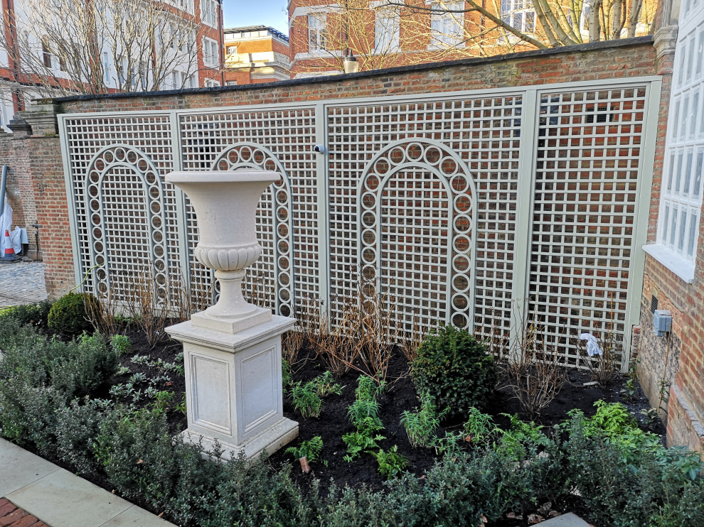 Foto di un giardino formale contemporaneo dietro casa in primavera con recinzione in legno