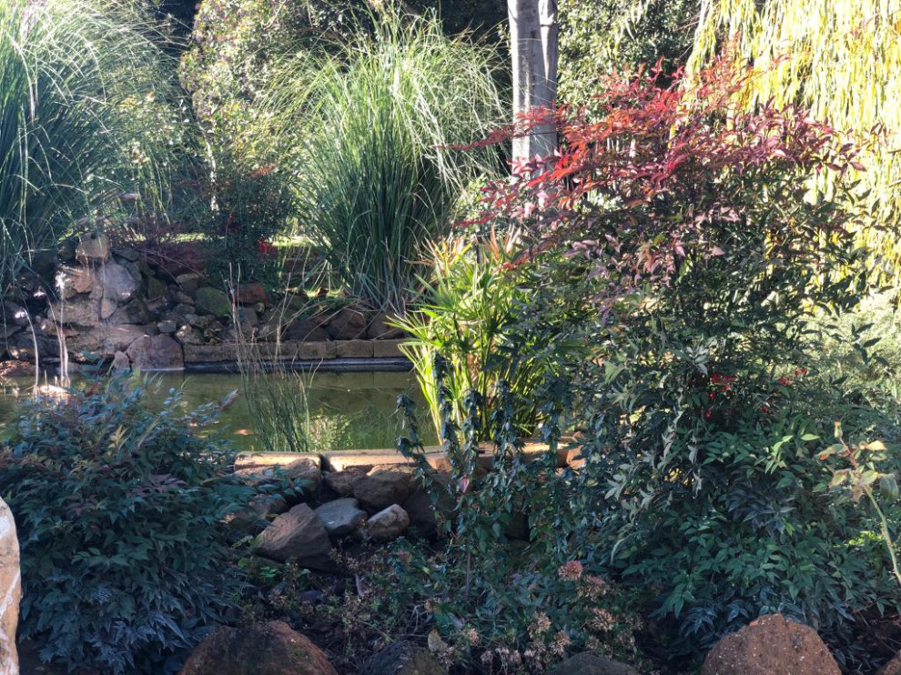 На фото: большой участок и сад на заднем дворе в стиле кантри с с каменным забором с
