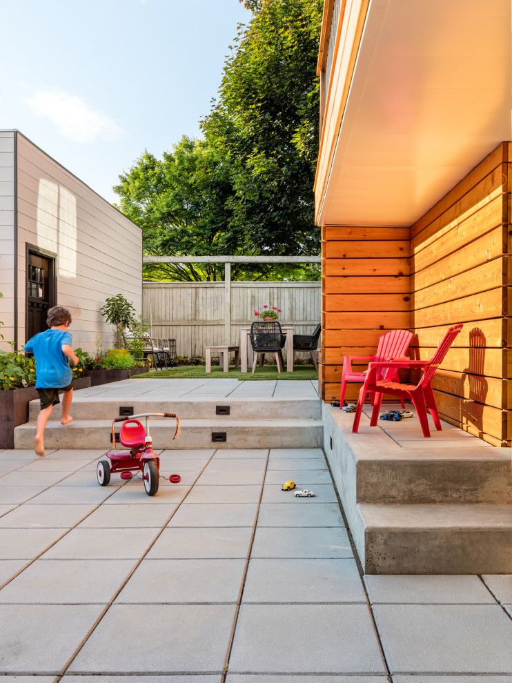 Modelo de patio actual pequeño en patio trasero con adoquines de hormigón
