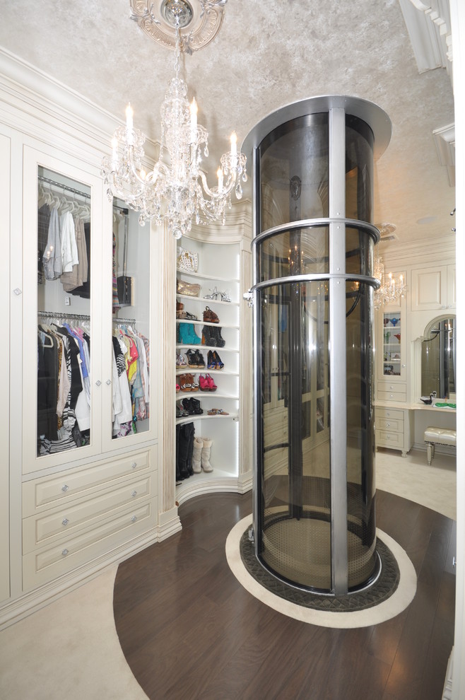Walk-in closet - large traditional women's dark wood floor walk-in closet idea in New York with white cabinets and raised-panel cabinets