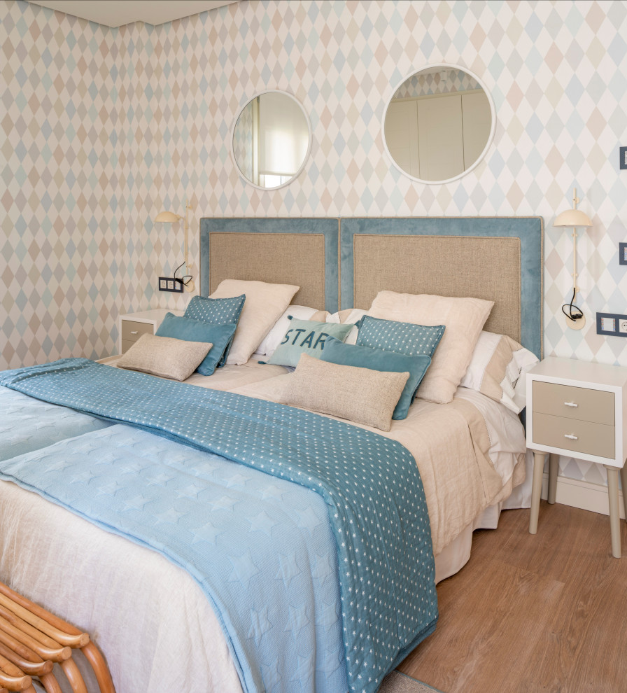 This is an example of a large traditional gender neutral kids' bedroom in Bilbao with laminate floors and wallpapered walls.