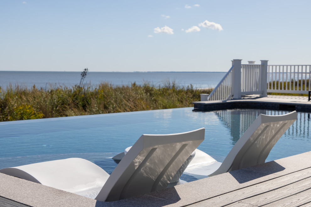 Foto di una piscina a sfioro infinito design personalizzata di medie dimensioni e dietro casa con una vasca idromassaggio e pedane