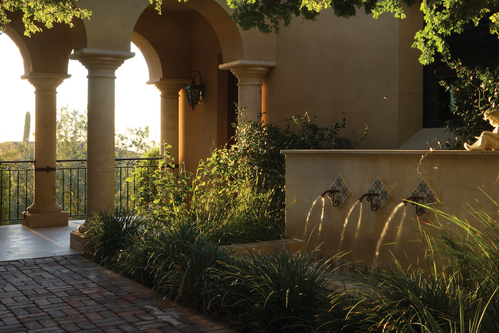 Large mediterranean side yard formal garden in Phoenix with a water feature.