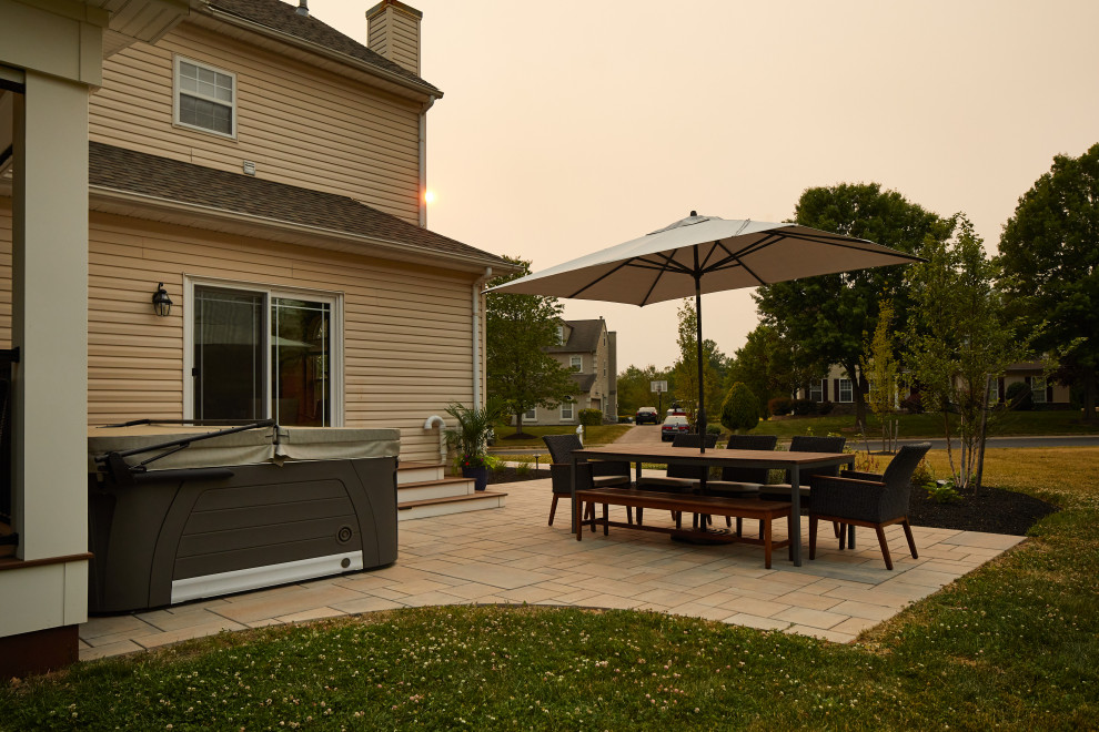 Immagine di un patio o portico design di medie dimensioni e dietro casa con pavimentazioni in cemento e un tetto a sbalzo