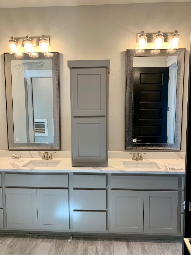 Example of a mid-sized transitional master gray tile porcelain tile, beige floor and double-sink double shower design with shaker cabinets, gray cabinets, a two-piece toilet, gray walls, an undermount sink, quartzite countertops, a hinged shower door, white countertops and a built-in vanity