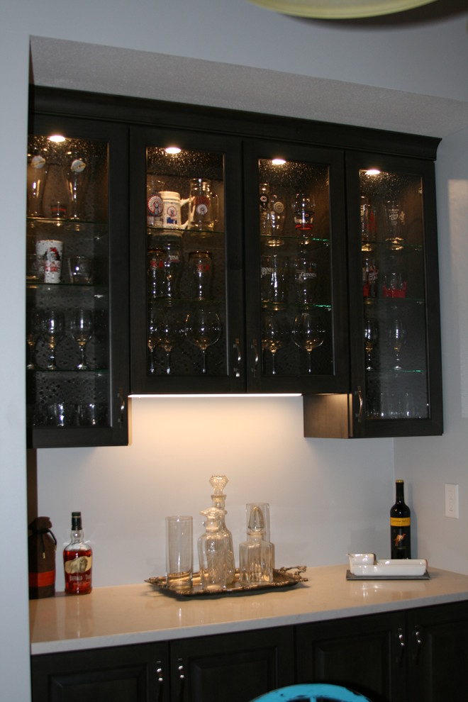Inspiration for a traditional single-wall home bar in Phoenix with glass-front cabinets and dark wood cabinets.