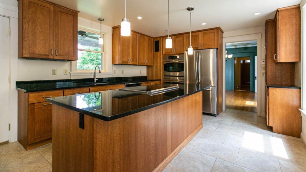 Large arts and crafts l-shaped separate kitchen in San Francisco with an undermount sink, shaker cabinets, medium wood cabinets, quartz benchtops, stainless steel appliances, with island, beige floor and black benchtop.
