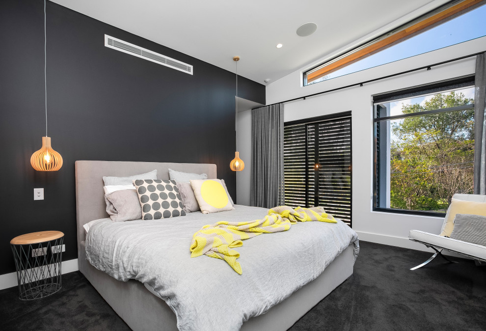 This is an example of a large contemporary master bedroom in Sydney with black walls, carpet and black floor.