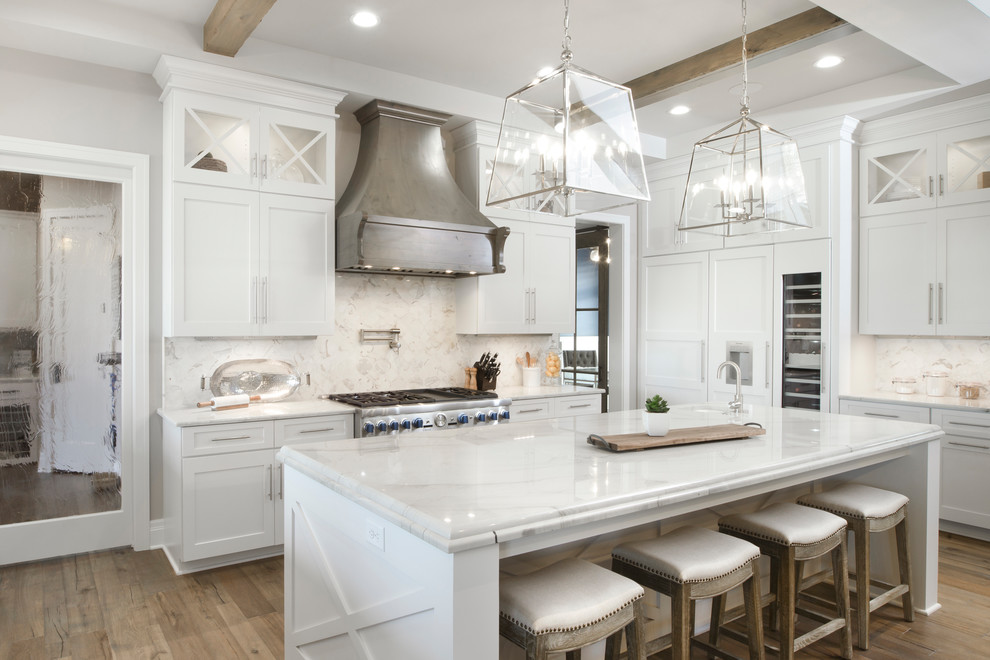 Inspiration for a transitional kitchen in Wichita with a single-bowl sink, shaker cabinets, white cabinets, white splashback, panelled appliances, medium hardwood floors, with island and white benchtop.