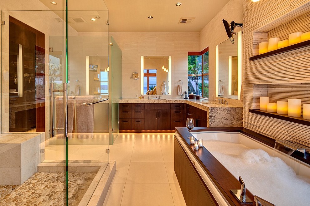 This is an example of a contemporary master bathroom in Seattle with flat-panel cabinets, dark wood cabinets, beige tile, beige walls, an undermount sink, granite benchtops, an undermount tub and matchstick tile.
