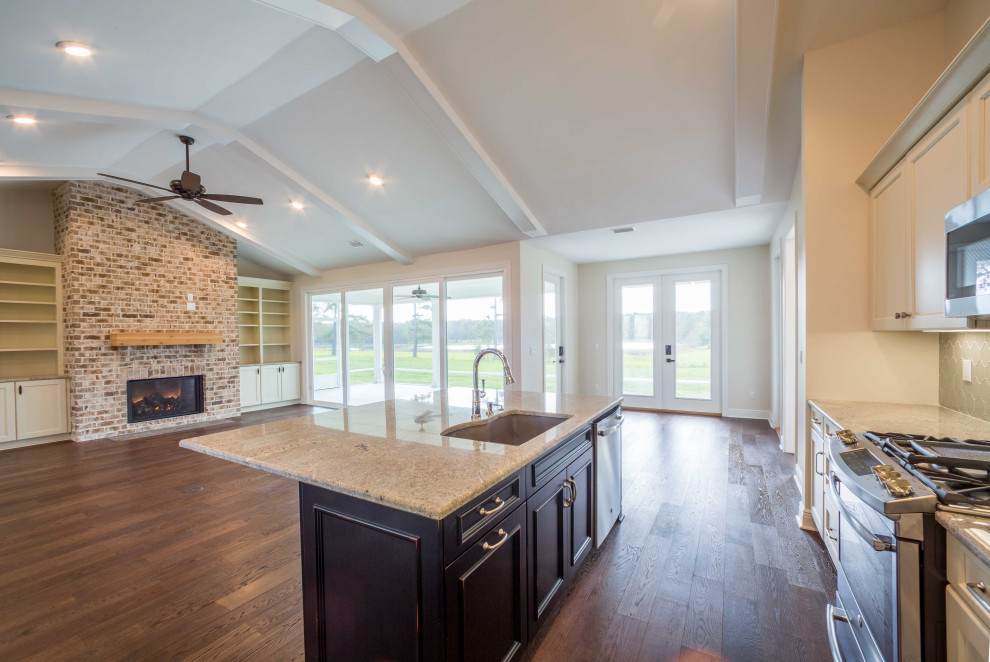 Mid-sized elegant galley medium tone wood floor and brown floor eat-in kitchen photo with an undermount sink, recessed-panel cabinets, white cabinets, granite countertops, green backsplash, glass tile backsplash, stainless steel appliances, an island and multicolored countertops