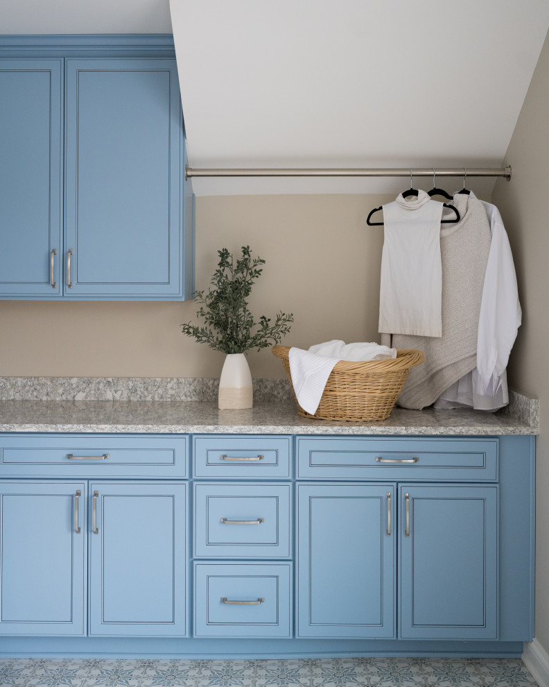 Foto di una sala lavanderia moderna di medie dimensioni con lavello sottopiano, ante blu, top in granito, pareti beige, pavimento con piastrelle in ceramica e lavatrice e asciugatrice affiancate