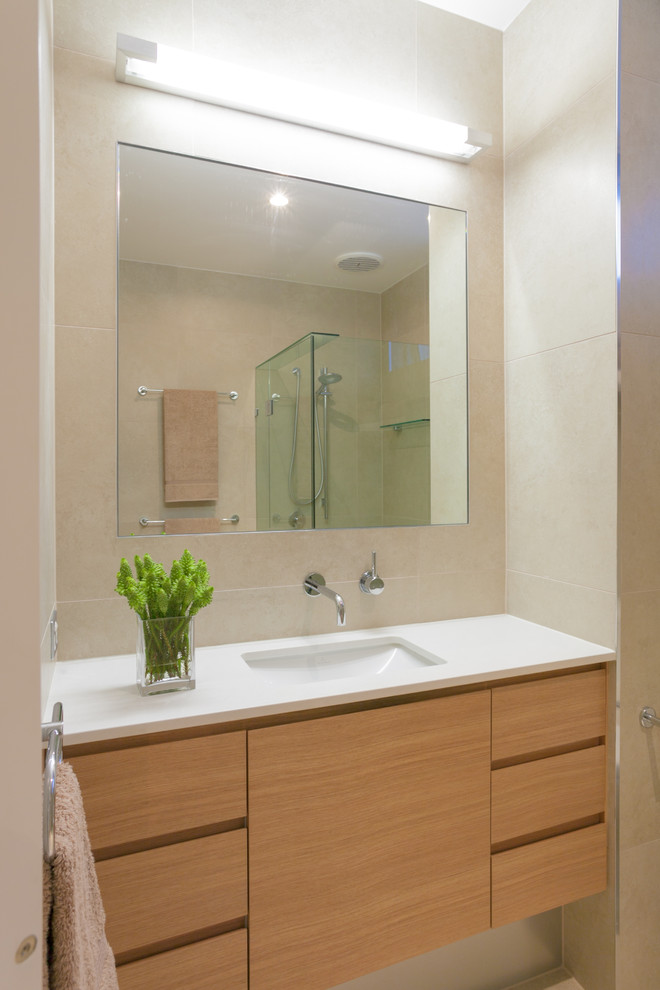 This is an example of a contemporary bathroom in Sunshine Coast with recessed-panel cabinets, light wood cabinets and engineered quartz benchtops.