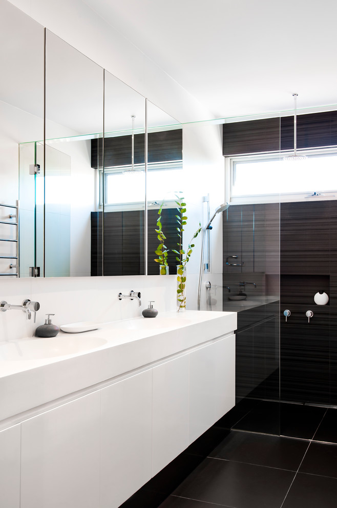 Inspiration for a mid-sized contemporary bathroom in Melbourne with an integrated sink, an open shower, white cabinets, engineered quartz benchtops, black tile, porcelain tile, white walls, porcelain floors and an open shower.