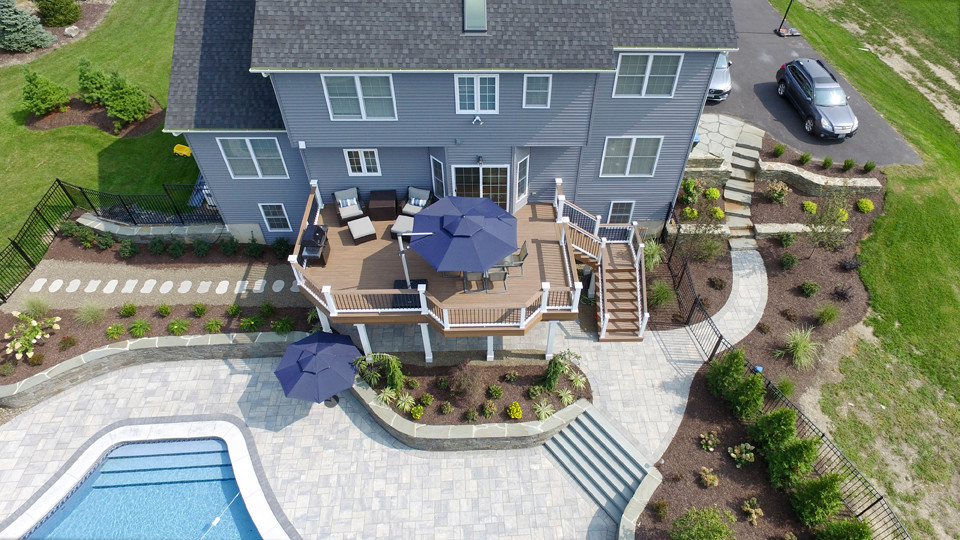 Modelo de terraza de estilo americano grande sin cubierta en patio trasero con barandilla de varios materiales