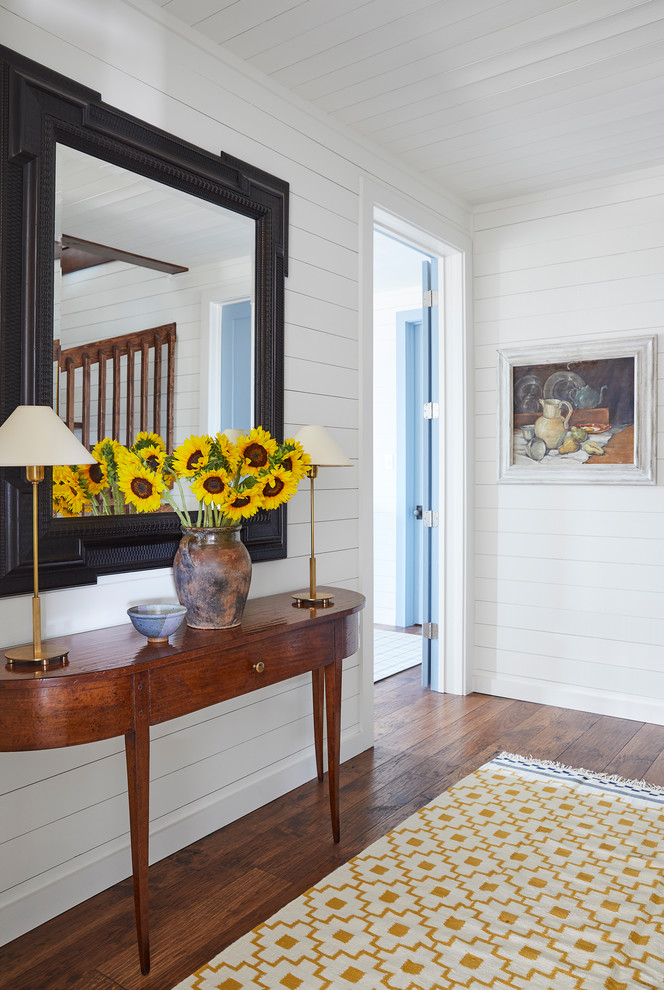 Mid-sized beach style hallway in Dallas with white walls, medium hardwood floors and brown floor.