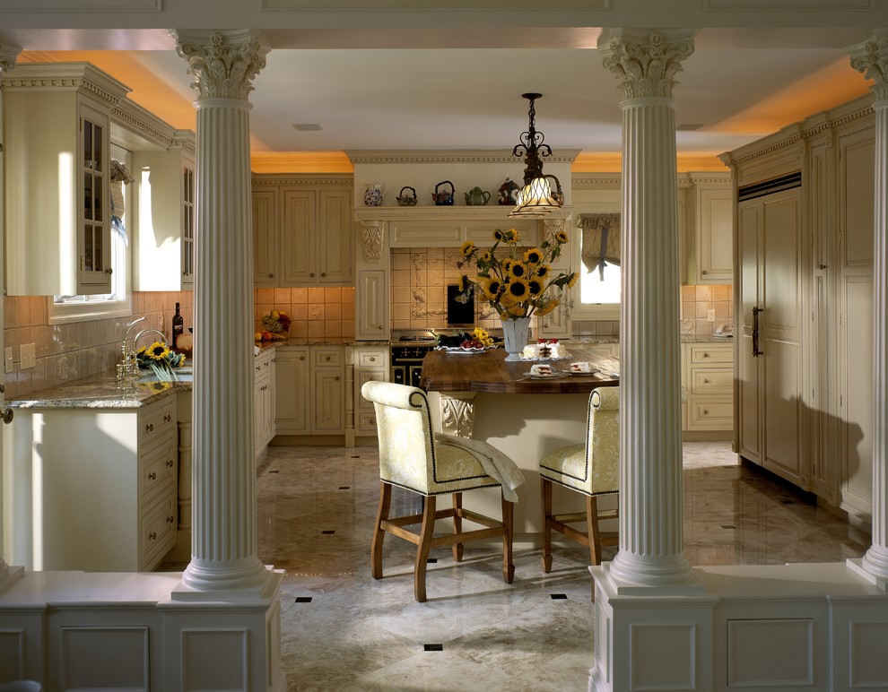 Design ideas for a large traditional u-shaped kitchen in New York with beaded inset cabinets, yellow cabinets, black appliances, a farmhouse sink, wood benchtops, ceramic splashback, marble floors and with island.
