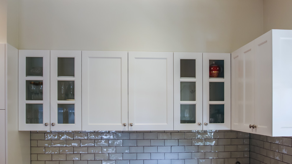 Design ideas for a large traditional l-shaped eat-in kitchen in Brisbane with a farmhouse sink, shaker cabinets, green cabinets, quartz benchtops, green splashback, subway tile splashback, white appliances, medium hardwood floors, with island and green benchtop.