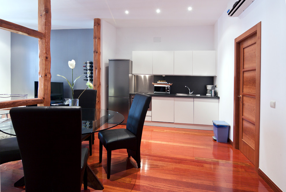 Ejemplo de comedor de cocina tradicional renovado de tamaño medio sin chimenea con paredes blancas y suelo de madera oscura