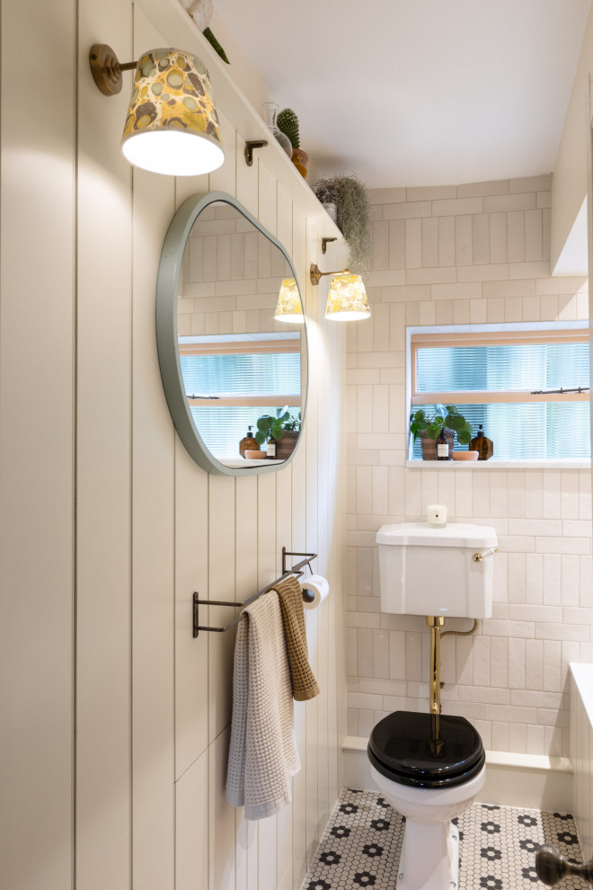 Пример оригинального дизайна: маленькая детская ванная комната: освещение в стиле кантри с фасадами с декоративным кантом, темными деревянными фасадами, накладной ванной, душем над ванной, раздельным унитазом, керамической плиткой, белыми стенами, столешницей из искусственного камня, разноцветным полом, шторкой для ванной, тумбой под одну раковину, встроенной тумбой и стенами из вагонки для на участке и в саду